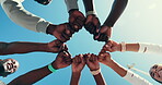 Fist, fitness and huddle with people on blue sky together from below for solidarity or unity. Exercise, hands in circle and motivation with athlete group outdoor for morning training or workout