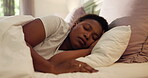 Tired, home and black woman with sleeping in bed for resting, dreaming and comfortable on pillow. Fatigue, person and peaceful in bedroom with morning nap, lazy weekend and relax under cozy blanket