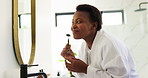 Jade roller, mirror and morning with black woman in bathroom for facial massage treatment. Beauty, product and skincare with face of happy person in apartment for antiaging or wellness routine