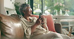 Mobile, think and senior woman in home for emotional message, love and good news for online dating. Phone, smile and person in living room in retirement for reflection, nostalgia or romantic memory