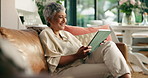 Mature woman, tablet and relax on sofa with smile, scroll and search for movies in living room. Person, happy and click on digital touchscreen, ebook app or streaming subscription for film in house
