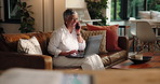 Funny, laptop and phone call with freelance woman on sofa in living room of home for remote work. Communication, computer and laughing with mature person in apartment for mobile discussion at night