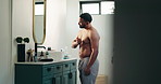 Man, mirror and flexing biceps in bathroom for fitness progress, muscle growth and workout results. Male person, reflection and inspection of body transformation, strong and grooming routine at house