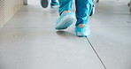Feet, walking and nurse with bed in hospital corridor with ER operation, treatment or surgery. Moving, medical emergency and healthcare worker pushing patient in hallway to ICU or theater in clinic.