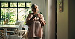 Mature woman, coffee and thinking in home for reflection, memory or sad with candle for mourning. Person, tea cup and wait by window at front door, remember or depression with grief for loss in house