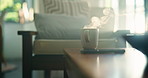 Hot, beverage and coffee with steam on table, apartment or caffeine for improved cognitive function. Home, tea and mug with cappuccino for breakfast, health benefits or drink for alertness in morning
