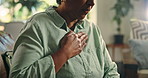 Mature, woman and hand on chest with cough for pain, asthma or tuberculosis at house. Sick, indigestion or heartburn with lung infection, health emergency or allergic reaction in home living room