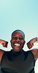Fitness, flexing and face of black man by blue sky for muscle workout, practice or training. Sports, happy and portrait of African athlete with biceps outdoor for exercise from below by mockup space.