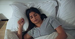 Sleeping, woman and restless in bed with nap, tired or fatigue with rest at home. Frown, fidget or break for female person in bedroom asleep for health, wellness and dreaming with discomfort at house