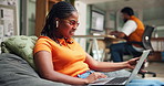 Creative, woman and earphones with laptop in office for article research, music and productivity. Media agency, content writer and singing on sofa for typing editor feedback, editing blog and happy