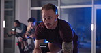 Cycling, spin class and man in gym on machine for cardio workout, exercise and training. Sports, health club and people on stationary bike for endurance, muscle strength and challenge for wellness