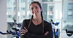 Arms crossed, face and smile of woman in gym for spin class, training or workout routine. Exercise, fitness and stationary bike with happy athlete in health club for cardio, cycling or performance