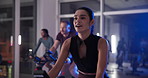 Stationary bike, people and woman in gym, night and cardio with body workout, energy and cycling Person, group or athlete in spin class, exercise machine or challenge with training, evening or health