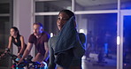 Bike, fitness and sweat with woman in spin class for cardiovascular improvement or cycling at night. Break, exercise and stationary spinning with athlete people in gym for late evening challenge