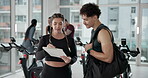 Man, woman and clipboard with discussion in gym for sign up, schedule and ideas for workout with info. Personal trainer, paperwork and conversation for fitness, checklist or agreement for wellness