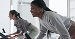 Group, women and stationary bike in gym for fitness, cycling and cardio workout. Smile, person and energy on bicycle machine of speed challenge, sports training and exercise performance in spin class