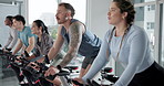 Happy people, instructor or fitness with cycling in spin class for group exercise or workout at gym. Active, team or community on stationary bicycle with coach for cardio training, health or wellness