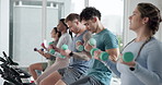 Weights, cycling class and people in gym with workout, activity or body training with coach. Dumbbells, personal trainer and group of athletes on bicycle machine for cardio exercise in fitness center