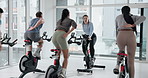 People, instructor and fitness with bike at gym for exercise, cardio training and indoor cycling. Group, coach and advice with bicycle machine, endurance workout and intense performance at spin class