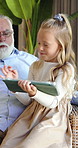 Tablet, grandfather and relax with child on sofa for streaming, bonding and online cartoon. Happy, love and retirement with senior person and girl in family home for digital entertainment and games