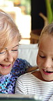 Tablet, grandma and support with child on sofa for streaming, bonding and online cartoon. Happy, games and retirement with senior person and girl in family home for digital entertainment and smile