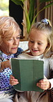 Tablet, grandma and love with child on sofa for streaming, bonding and online cartoon. Happy, games and retirement with senior person and girl in family home for digital entertainment and smile