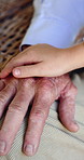 Support, senior person and care for child, holding hands or affection for grandparent, home or love. Family, together and bonding with kid in house, retirement and touch for compassion or grandpa