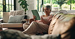 Senior woman, relax and tablet on sofa for playing online bingo, gambling app or internet surfing. Retirement, happy person and digital tech in home for gaming site, streaming subscription or ebook