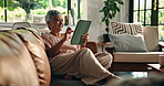 Sofa, senior woman and laughing with tablet for online streaming, news website and relax at home. House, old person and thinking with digital for application, chat and social media post in retirement