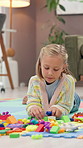 Building blocks, playing and kid on floor in home for game, creativity and fine motor skills. House, girl and child with toys for learning, problem solving and cognitive development for education