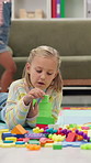 Building tower, playing and child in home for learning, creativity or motor skills on floor. House, girl and kid with cube toys for educational game, hand eye coordination and cognitive development