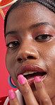 Beauty, lipstick and face of black woman in studio with makeup, cosmetics or shine on red background. Fashion, salon and portrait of person with lip gloss for color, glow and apply with trendy style