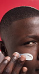 Black man, skincare and cream in studio, face and dermatology in closeup by background. African person, lotion and moisturizer for glow with application, results and product for benefits in Nigeria