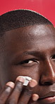 Face, cream and black man in studio, skincare and dermatology on red background. African person, portrait and model with cosmetics, creme or aesthetic with wellness, beauty and facial spf with lotion
