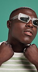 Attitude, sunglasses and face of black man in studio for confidence, trendy clothes and style. Serious, gen z and portrait of person with accessory for fashion, pride and aesthetic on blue background