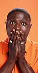 Surprise, cover mouth and face of black man in studio for reaction, facial expression and shocked. Orange background, emoji and portrait of person with hands for omg, news announcement and gossip