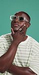 Studio, thinking and man with sunglasses, fashion and decision for trendy clothes and contemplating. Green background, remember and black person with ideas for unique style, shades and serious