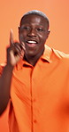 Face, dancing and black man in studio, excited and achievement on orange background. African person, smile and model with happiness, energy or celebration with music, winner and funny with confidence