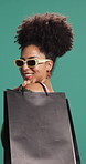 Woman, shopping bag and happy with sunglasses in studio, deal or sale for fashion by background. African person, smile and pride with product, retail therapy and excited for discount with clothes