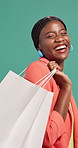 Black woman, shopping bag and happy with face in studio, laugh and sale with fashion by background. Person, smile and package in portrait for deal, retail therapy or discount with clothes in Nigeria