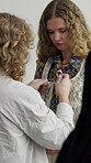 Woman, fashion and stylist help with model for photoshoot fitting, getting ready and backstage. Designer, people and dressing with clothes of film production, wardrobe and change for magazine agency
