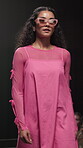 Stage, fashion model and woman on walk, performance and showcase of clothes, confident and creative. Advertising, outfit and person with stylish dress, bold and colorful with eyewear on runway
