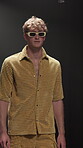 Fashion week, man and walk with sunglasses on runway for clothes showcase, couture or designer brand. Catwalk show, model and trendy wardrobe on stage for summer collection, menswear and confidence