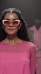 Stage, runway model and woman on walk, performance or showcase of clothes, confident and sunglasses. Advertising, outfit and person with stylish dress, bold and colorful with eyewear on fashion show