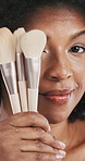 African woman, face and makeup brush in studio with smile, playful and equipment by background. Mature person,  happy and cosmetic tools with pride, results and beauty with transformation in Kenya