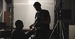 Film, maintenance and men with camera on set for lens adjustment, lighting and equipment settings. Cinematography, operator and videographer with assistant for shooting, production and filmmaking