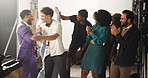 Applause, handshake and success with people on set together for film or videography satisfaction. Clapping, high five or wrap with director and talent behind the scenes for advertising or production