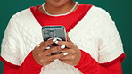 Phone, hands and woman in studio with networking, communication or connectivity on mobile app. Technology, online and female person with cellphone for texting with contact by green background.