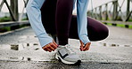 Runner, ties shoes and fitness with woman in city for start, marathon practice and health. Wellness, exercise and sports workout with person training outdoor on bridge for resilience and cardio