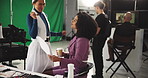 Woman, makeup artist and ready on film set with script, director and staff for production. Actress, cosmetics and touchup with green screen, cinematography and document for lines at movie studio